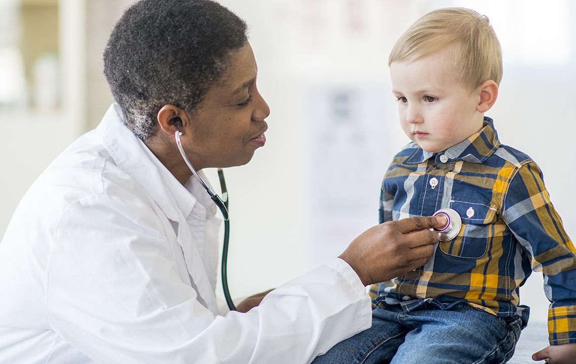 Doctor listening to child's heartbeat